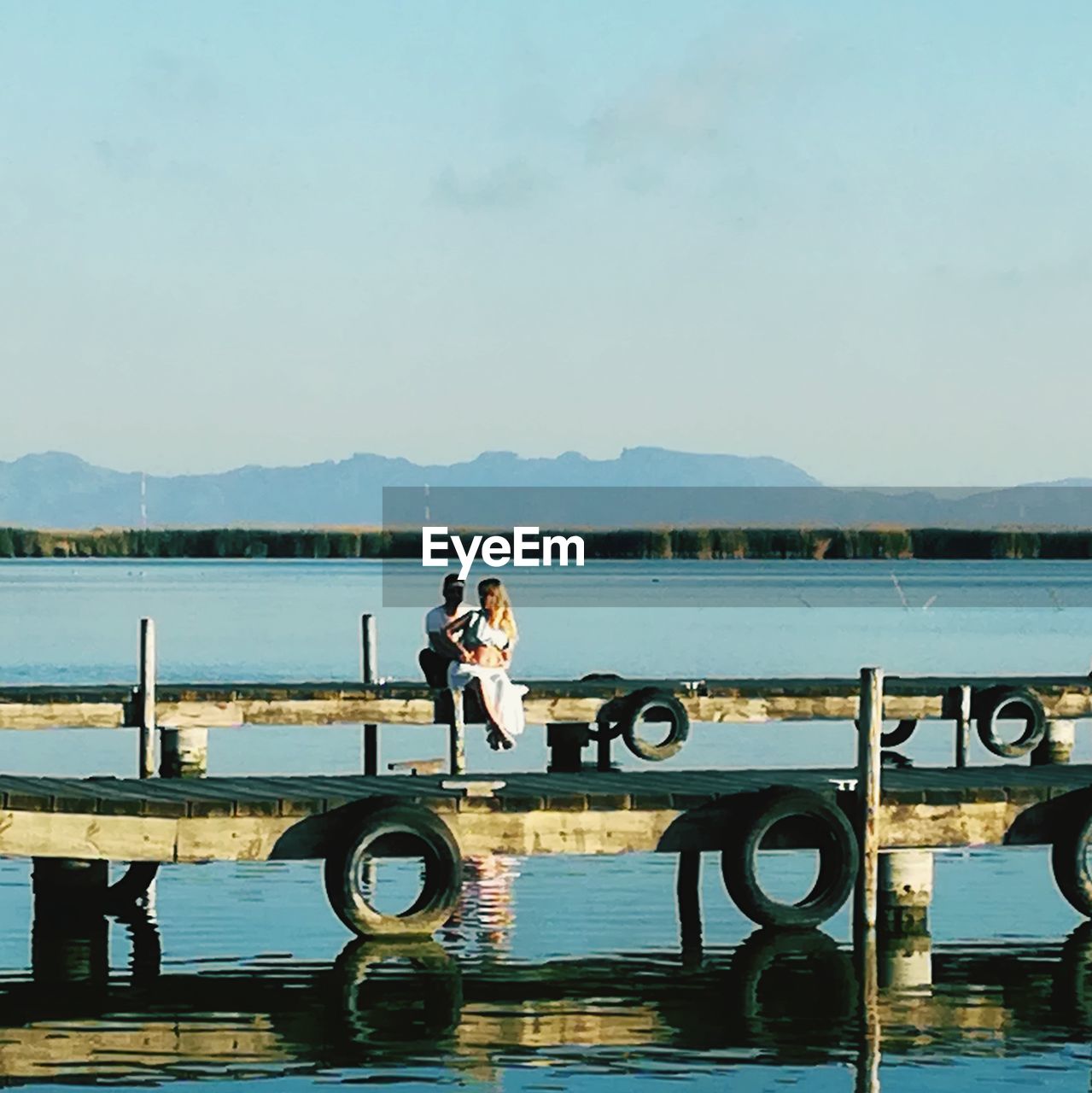 WOMAN ON LAKE AGAINST SKY