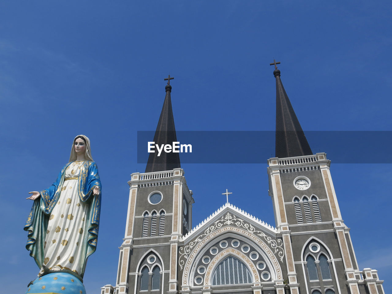 Low angle view of statue against building against clear blue sky