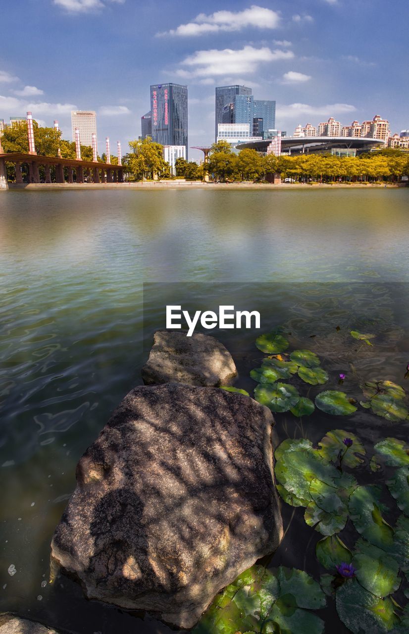 SCENIC VIEW OF RIVER BY CITYSCAPE AGAINST SKY