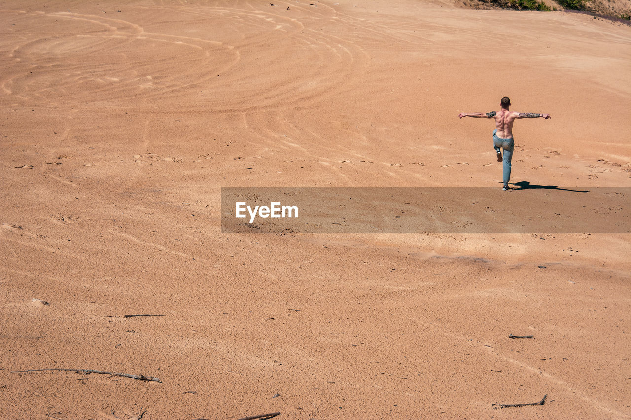 Full length of man walking on sand at sandy beach