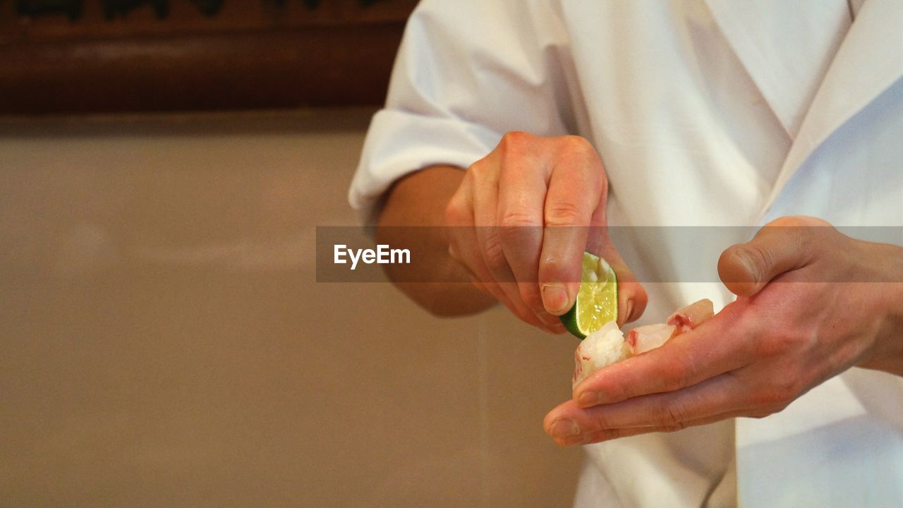 Close-up of man holding lemon