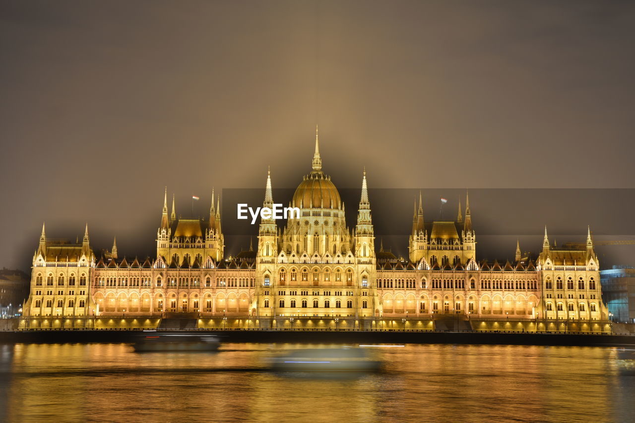 Illuminated hungarian parliament building by river at night