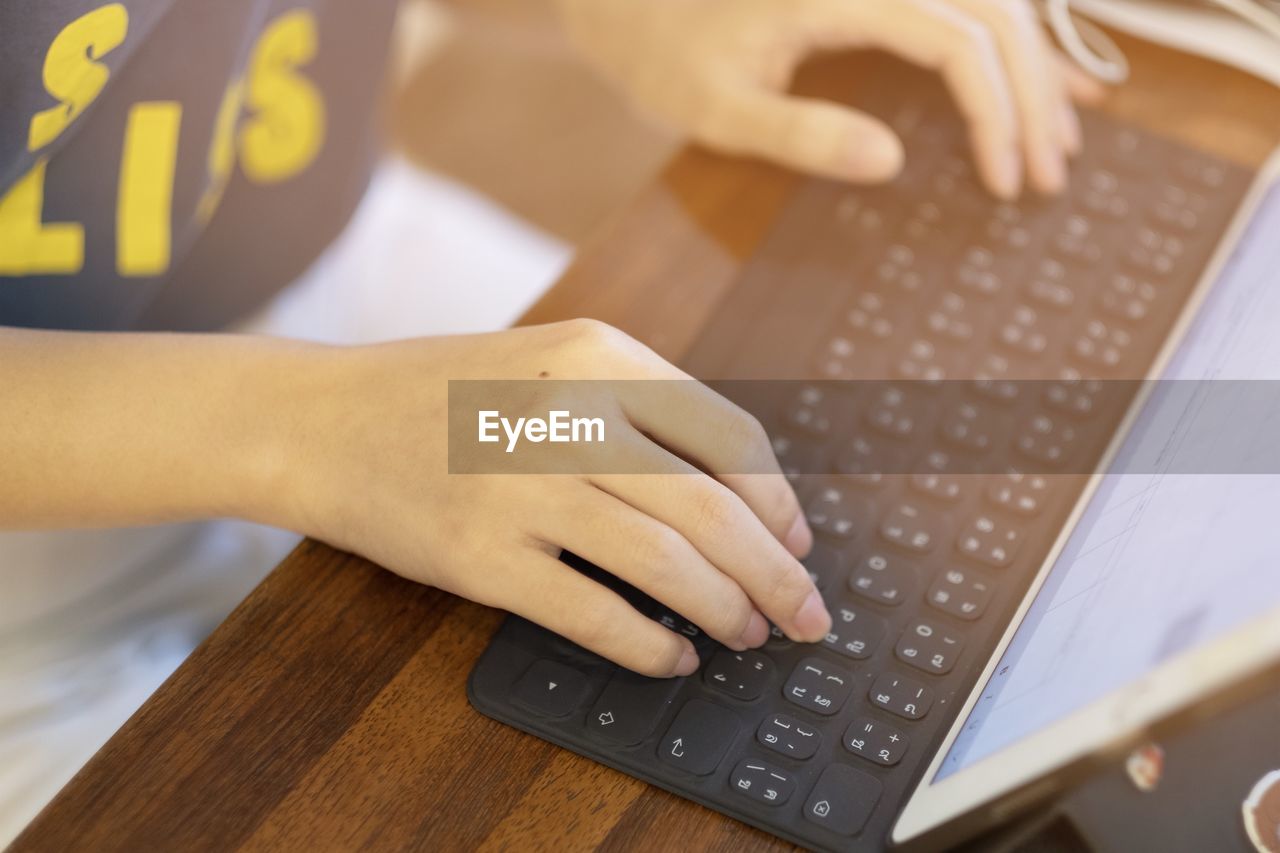 Midsection of woman using laptop on table