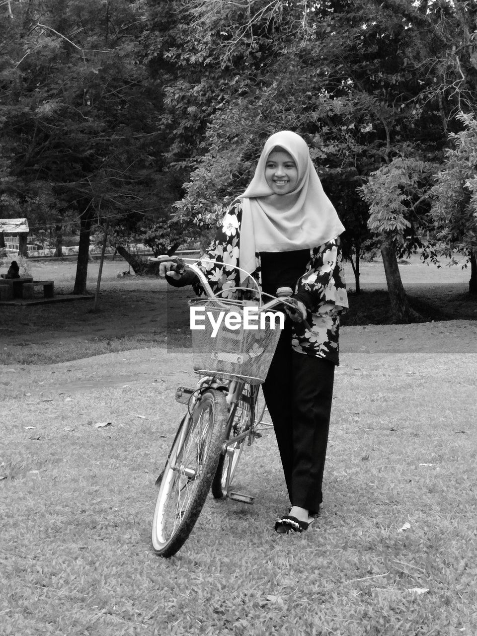 Woman in hijab with bicycle on field
