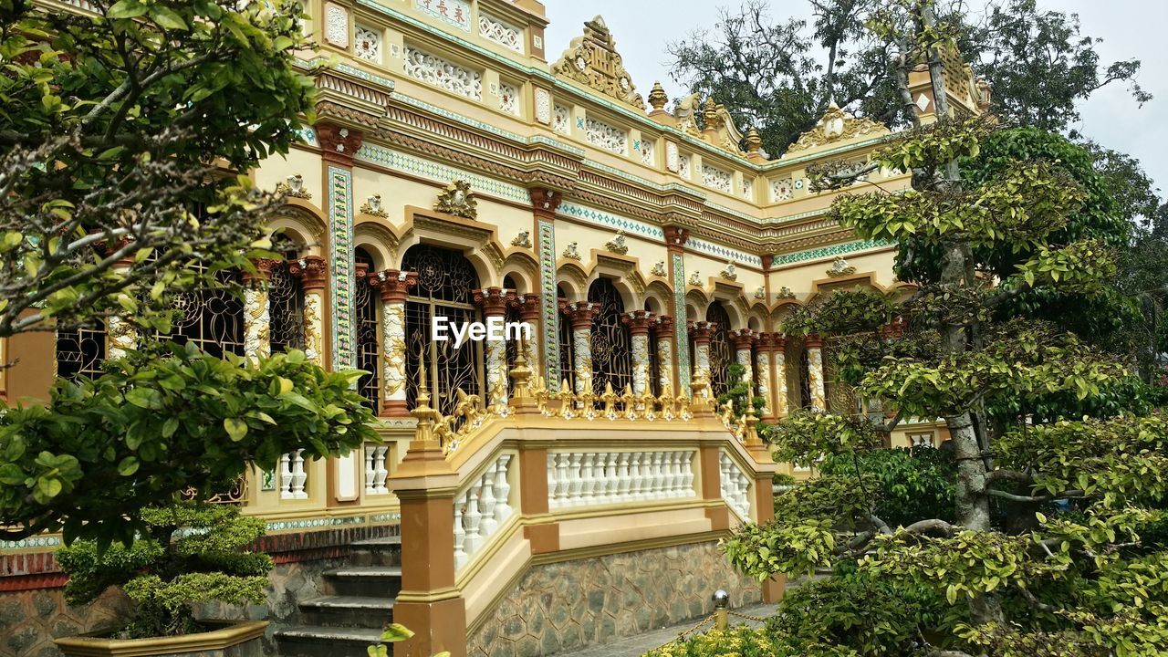 FACADE OF BUILDING WITH TREES IN BACKGROUND