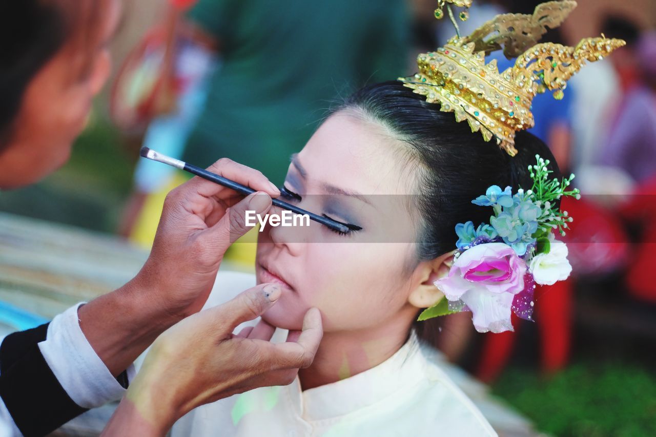 Artist applying eyeshadow on young woman