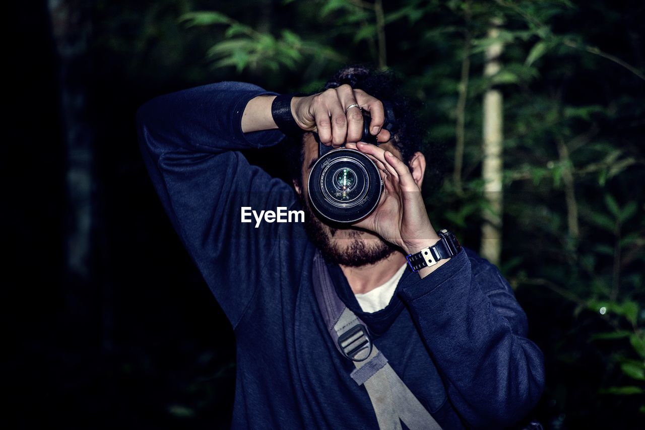 PORTRAIT OF MAN PHOTOGRAPHING ON CAMERA