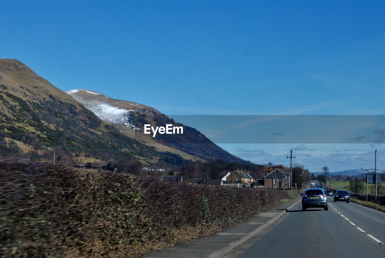 CAR ON ROAD AGAINST SKY