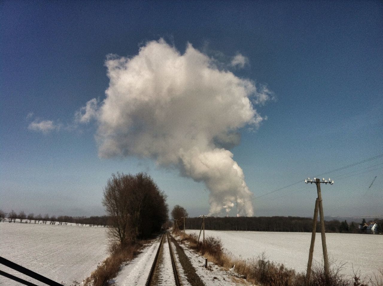 Factories emitting smoke seen through train windshield