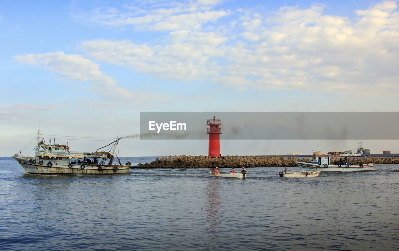 Boats moored in sea against sky