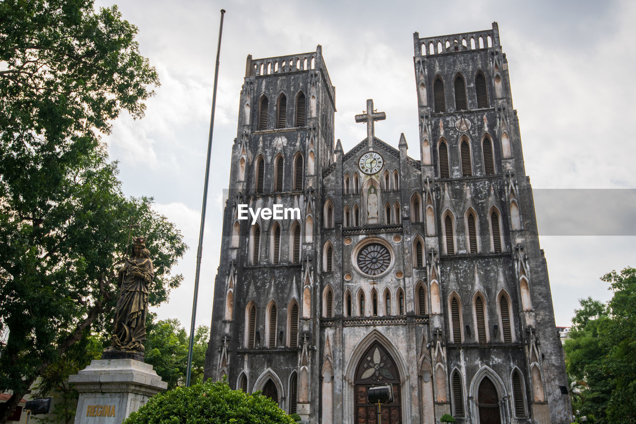 LOW ANGLE VIEW OF CHURCH AMIDST BUILDINGS AGAINST SKY