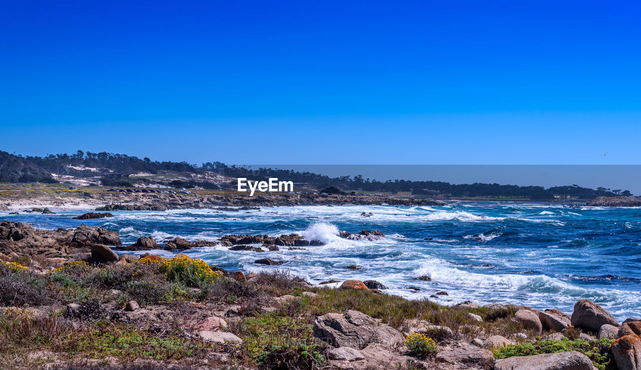 Scenic view of sea against clear blue sky