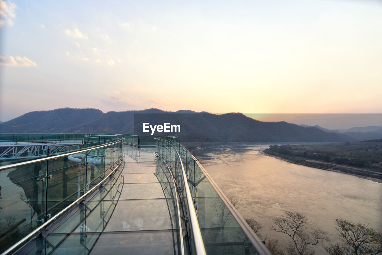 HIGH ANGLE VIEW OF RIVER AMIDST MOUNTAINS AGAINST SKY