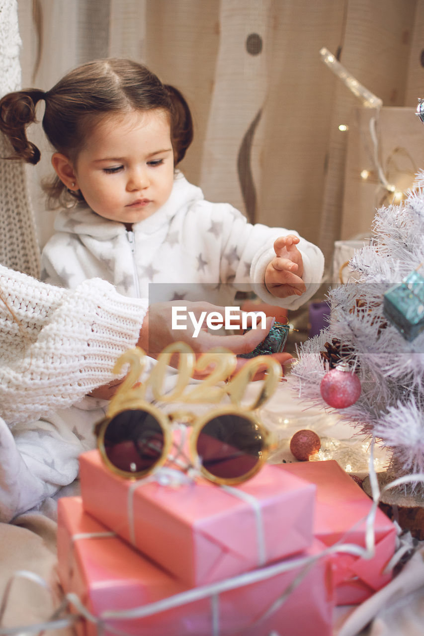 Cute girl with mother sitting with toy at home