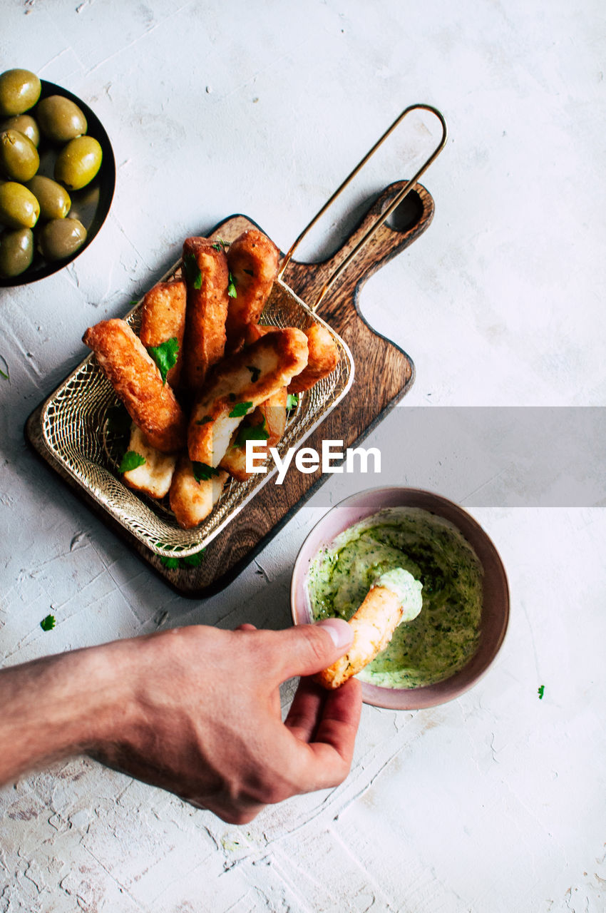 Cropped hand of person holding food on table