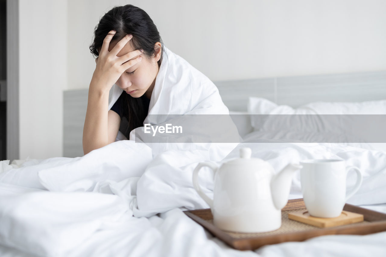 WOMAN SITTING ON BED