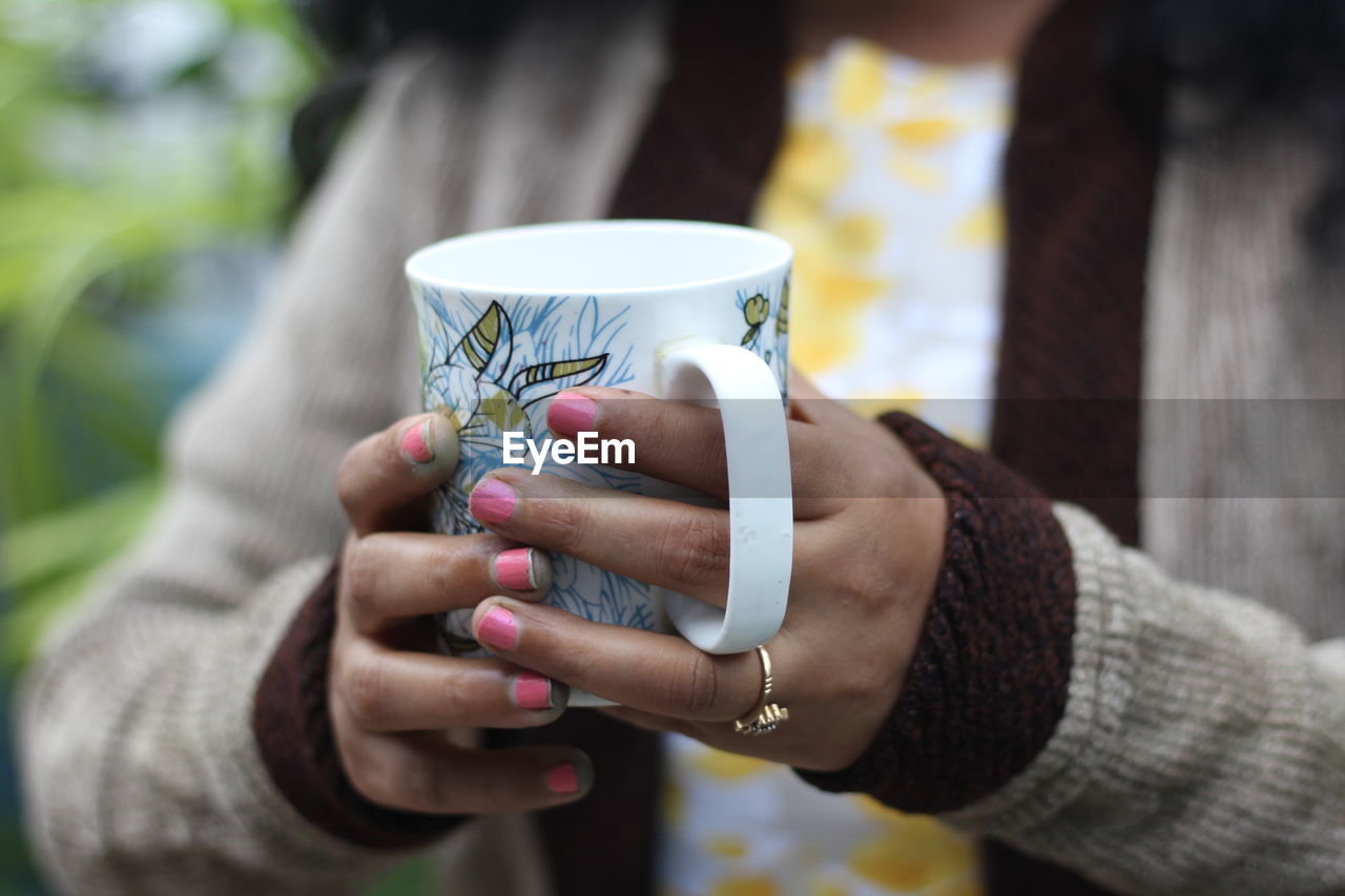 Close-up of hand holding coffee cup