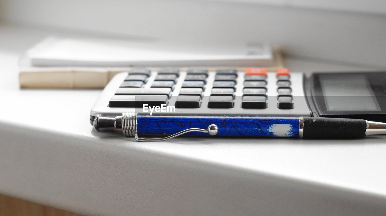 Close-up of calculator and spiral notebooks on table