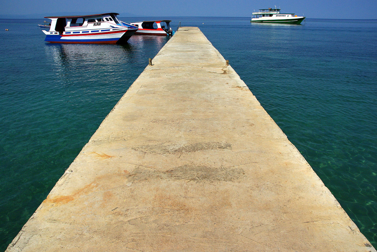 Boats moored on sea against sky