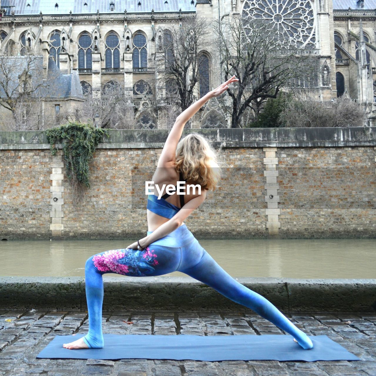 Full length of woman exercising by canal in city