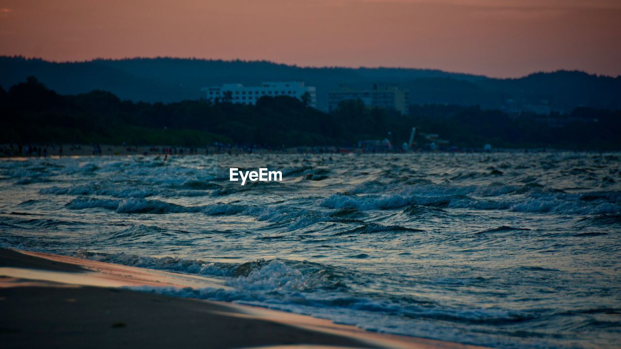 Waves splashing in sea against sky