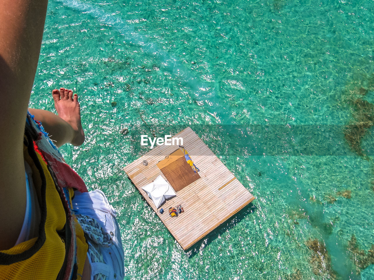 Low section of woman paragliding over sea