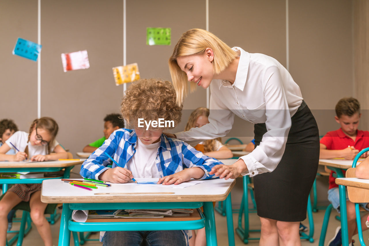 Teacher teaching student at classroom