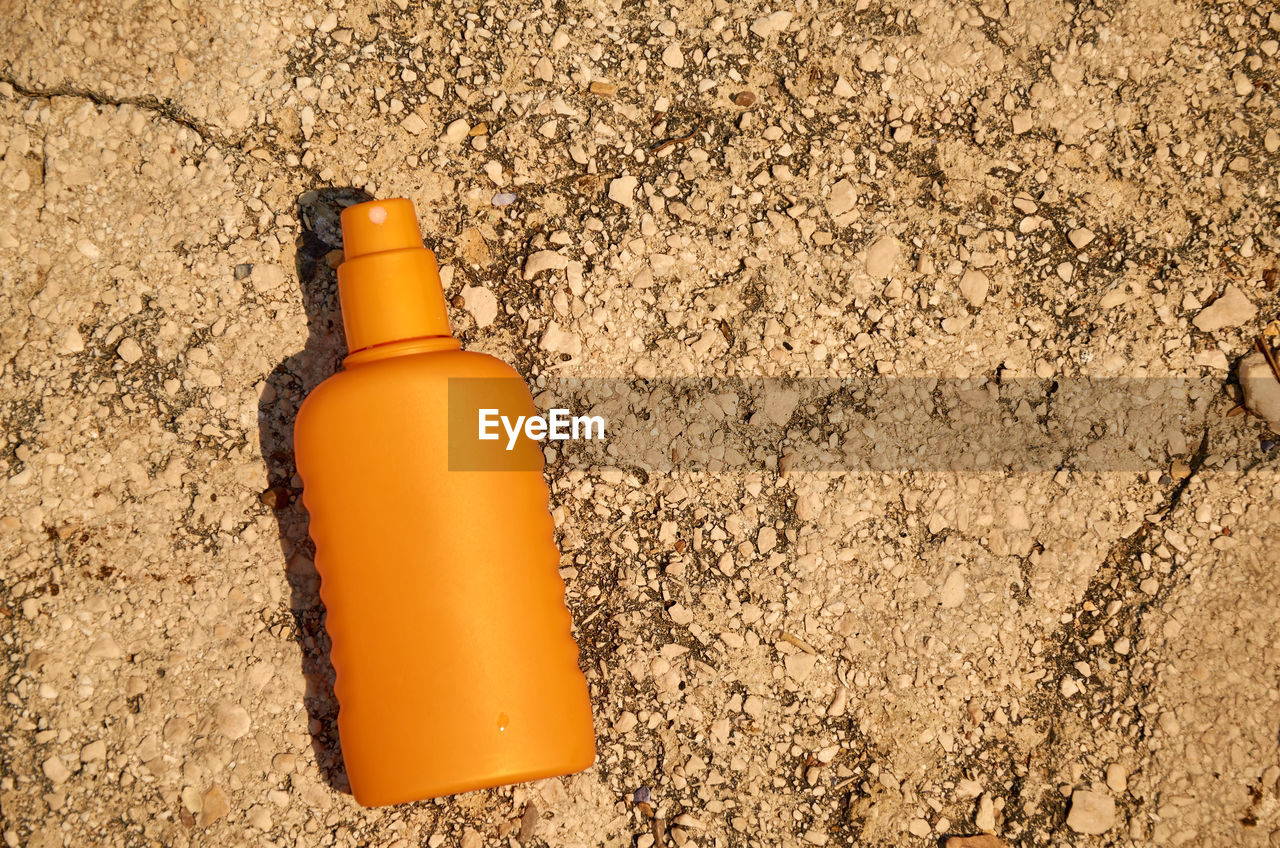 Orange container of a sun protection cream on a stone - surface suitable for a text