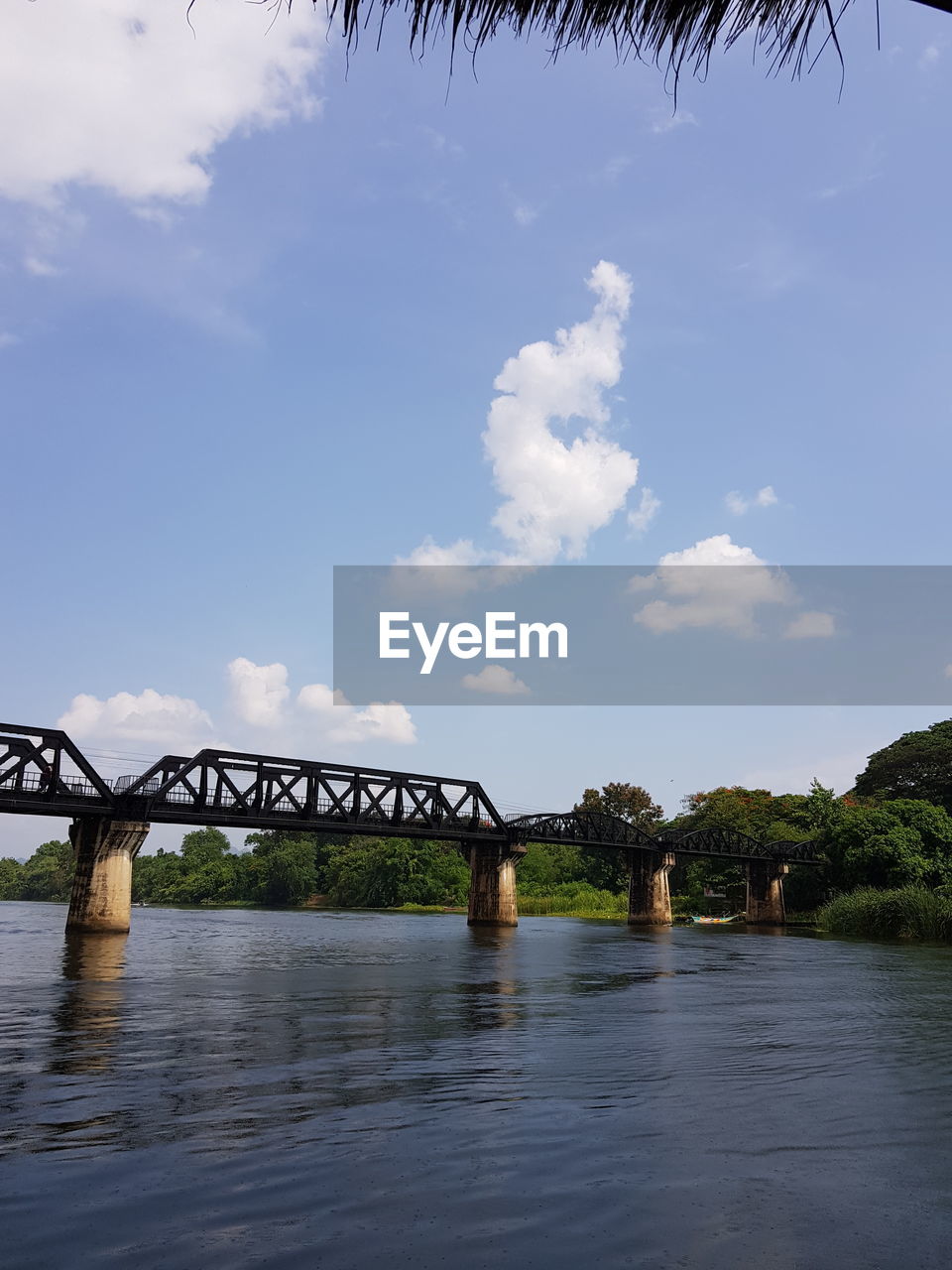 BRIDGE OVER RIVER BY TREES AGAINST SKY