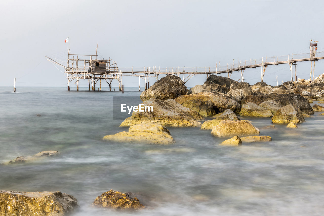 SCENIC VIEW OF ROCKS BY SEA AGAINST SKY