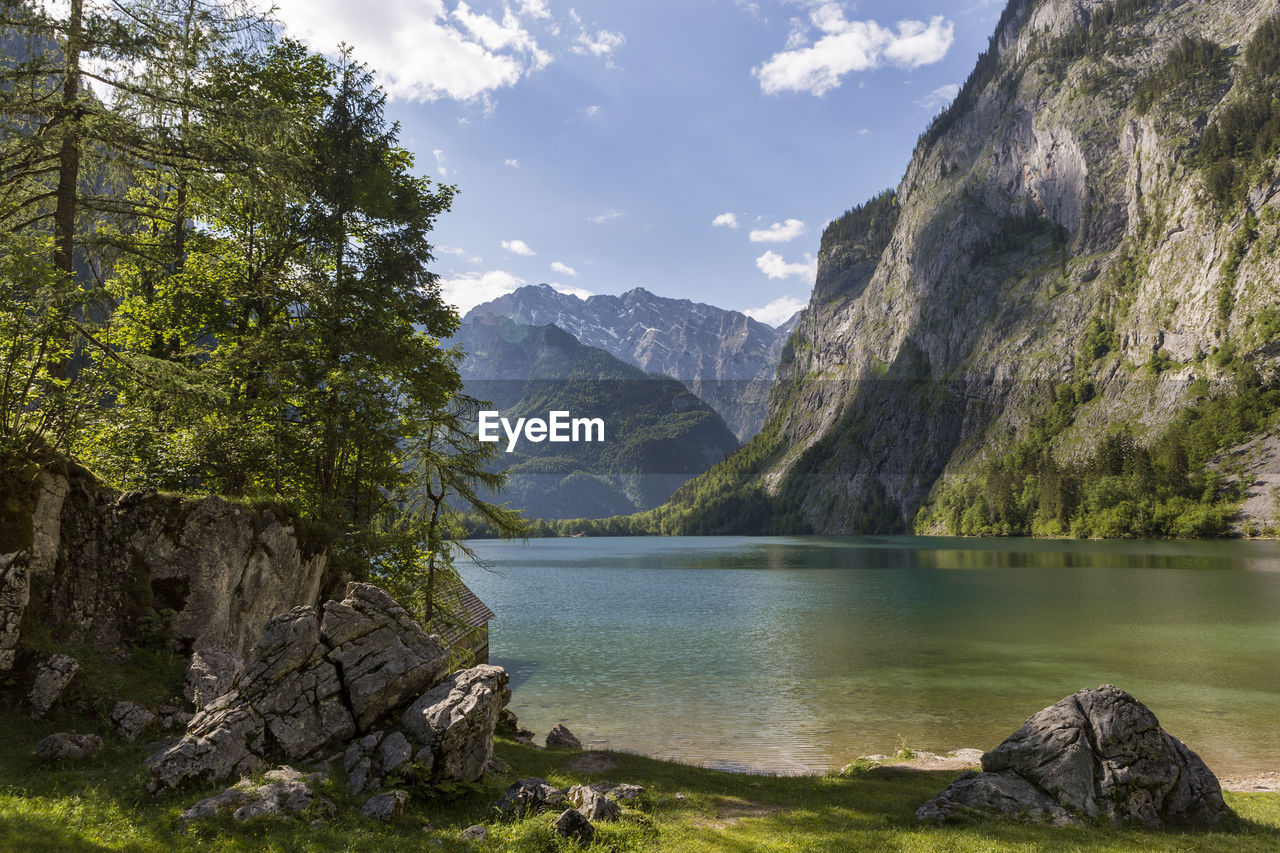 scenic view of lake by mountain against sky