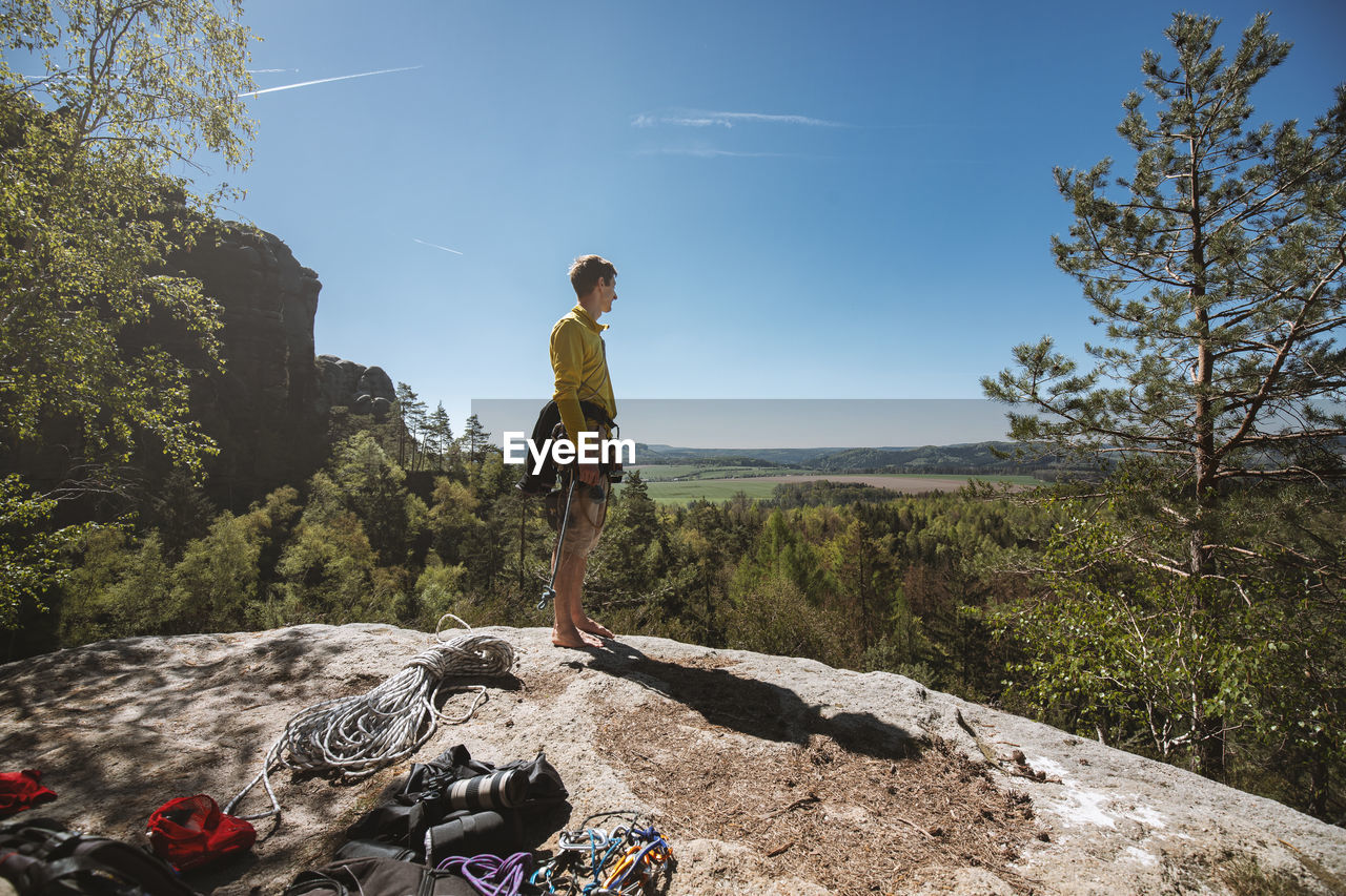 MAN BY ROCK AGAINST SKY