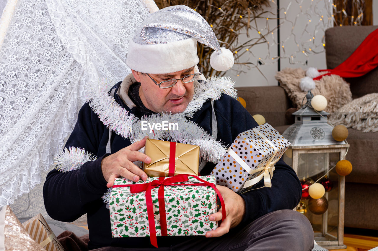 Midsection of man holding hat while sitting in box