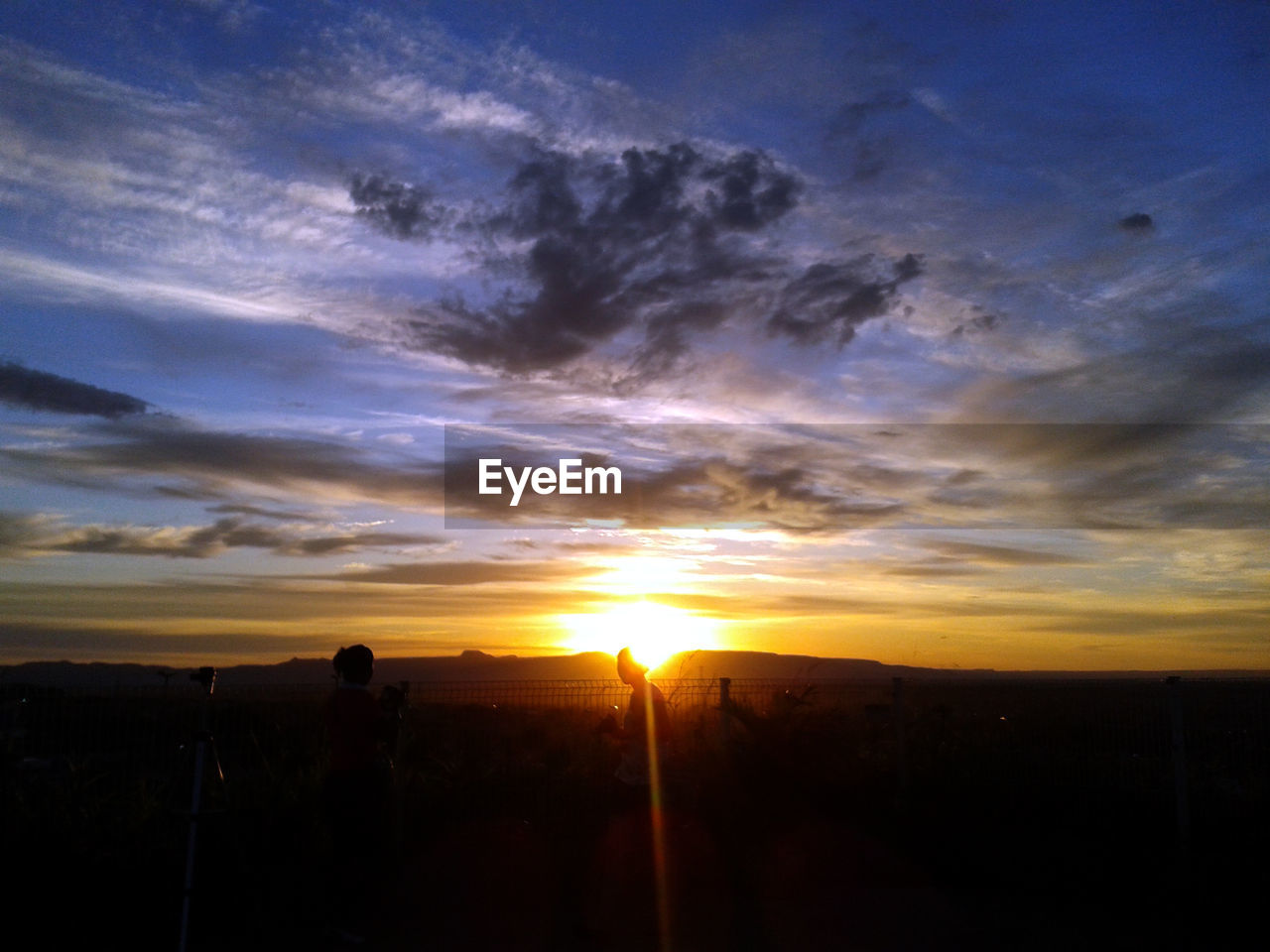 Silhouette landscape against sunset sky