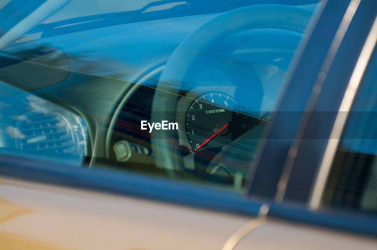 CLOSE-UP OF CAR WINDOW WITH BLUE REFLECTION