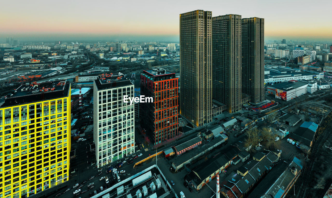 HIGH ANGLE VIEW OF MODERN BUILDINGS AGAINST SKY IN CITY