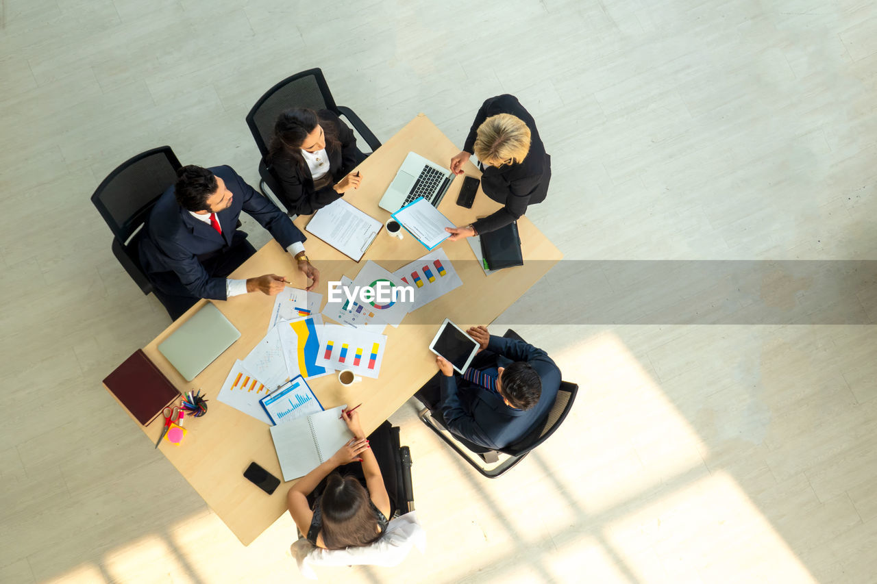 HIGH ANGLE VIEW OF PEOPLE ON TABLE WITH TEXT