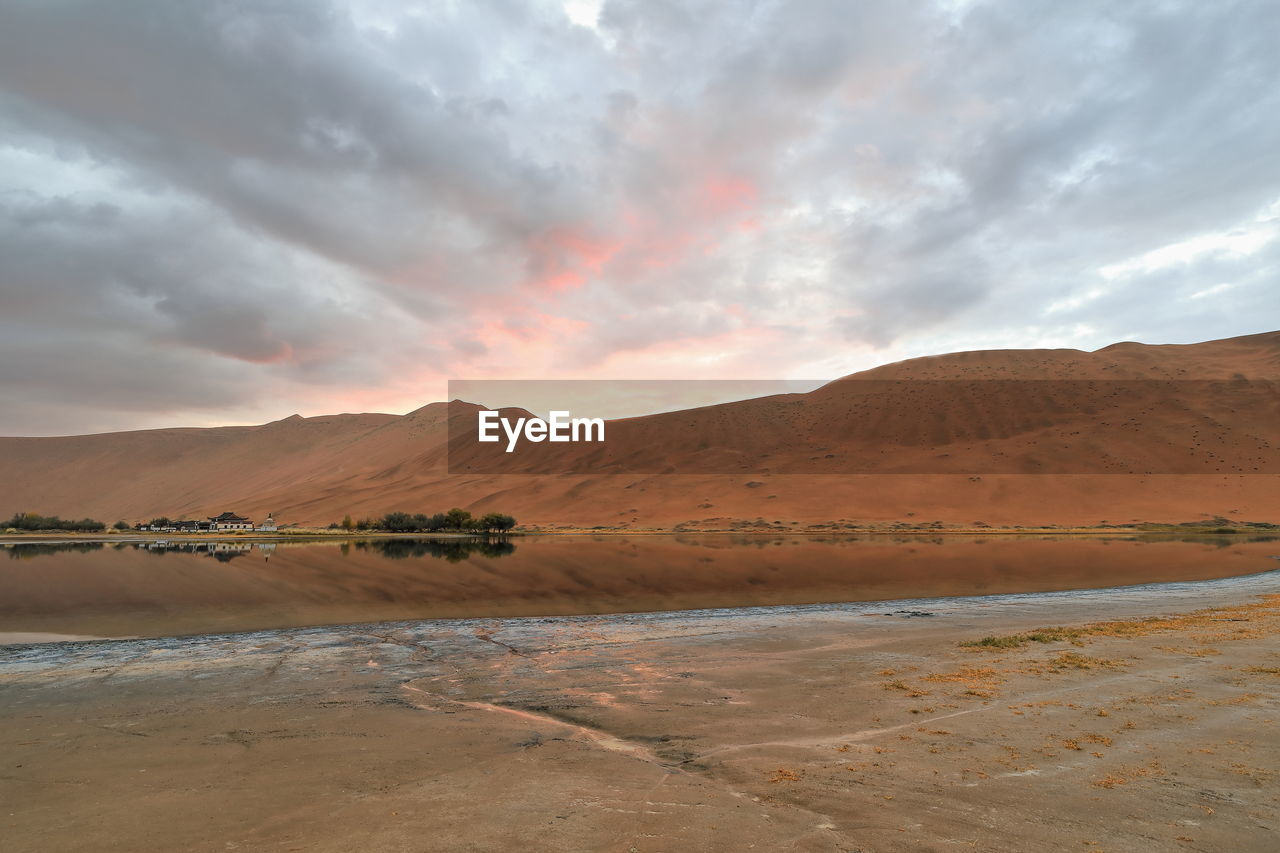 1118 sumu jaran lake and badain jaran desert temple-sand megadunes reflected on mirror water. china.