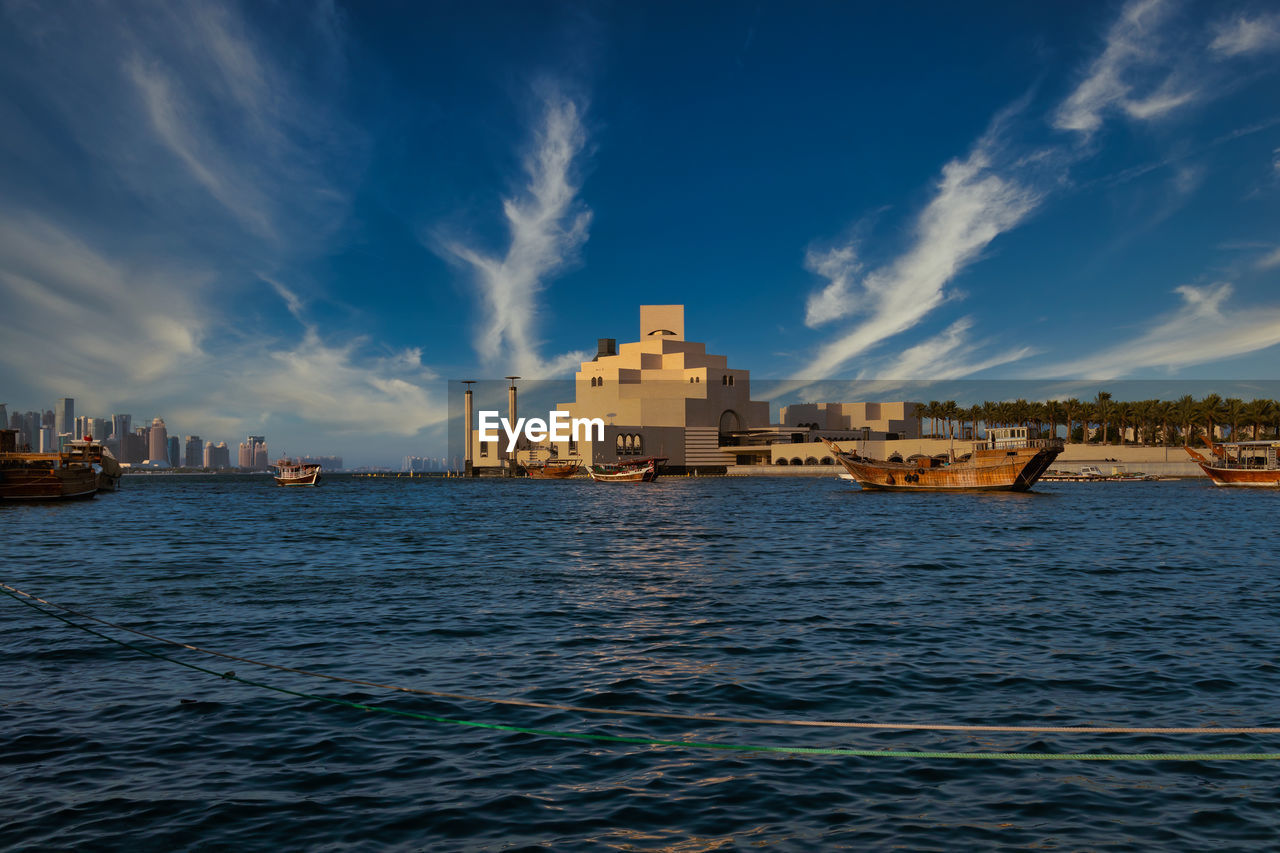 Museum of islamic art , doha, qatar in daylight exterior view with arabic gulf and dhow 