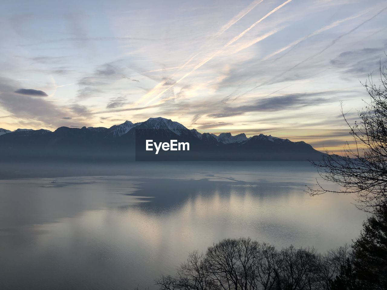 Scenic view of lake and mountains against sky during sunset