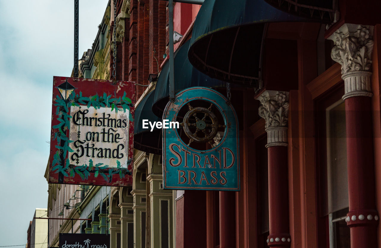 LOW ANGLE VIEW OF TEXT ON BUILDING AGAINST SKY