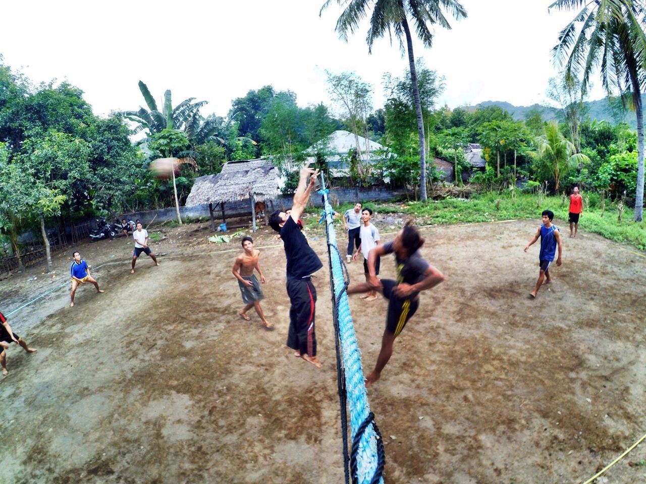 Men playing volleyball on field