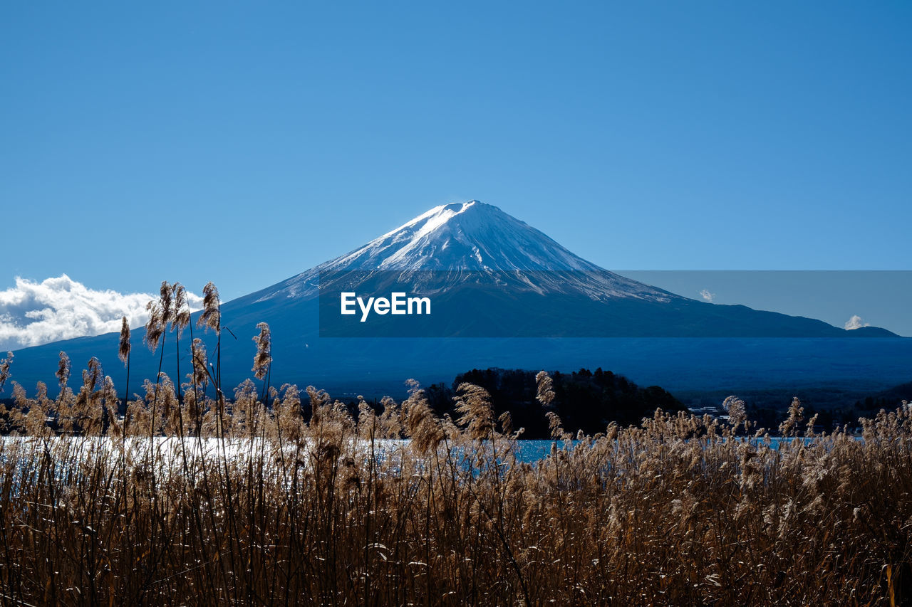 Scenic view of snowcapped mountains against clear blue sky