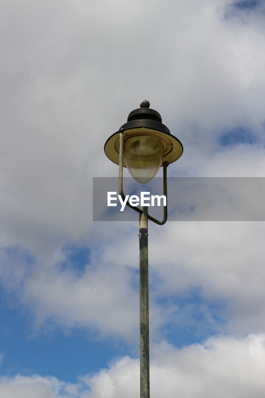 Low angle view of street light against cloudy sky