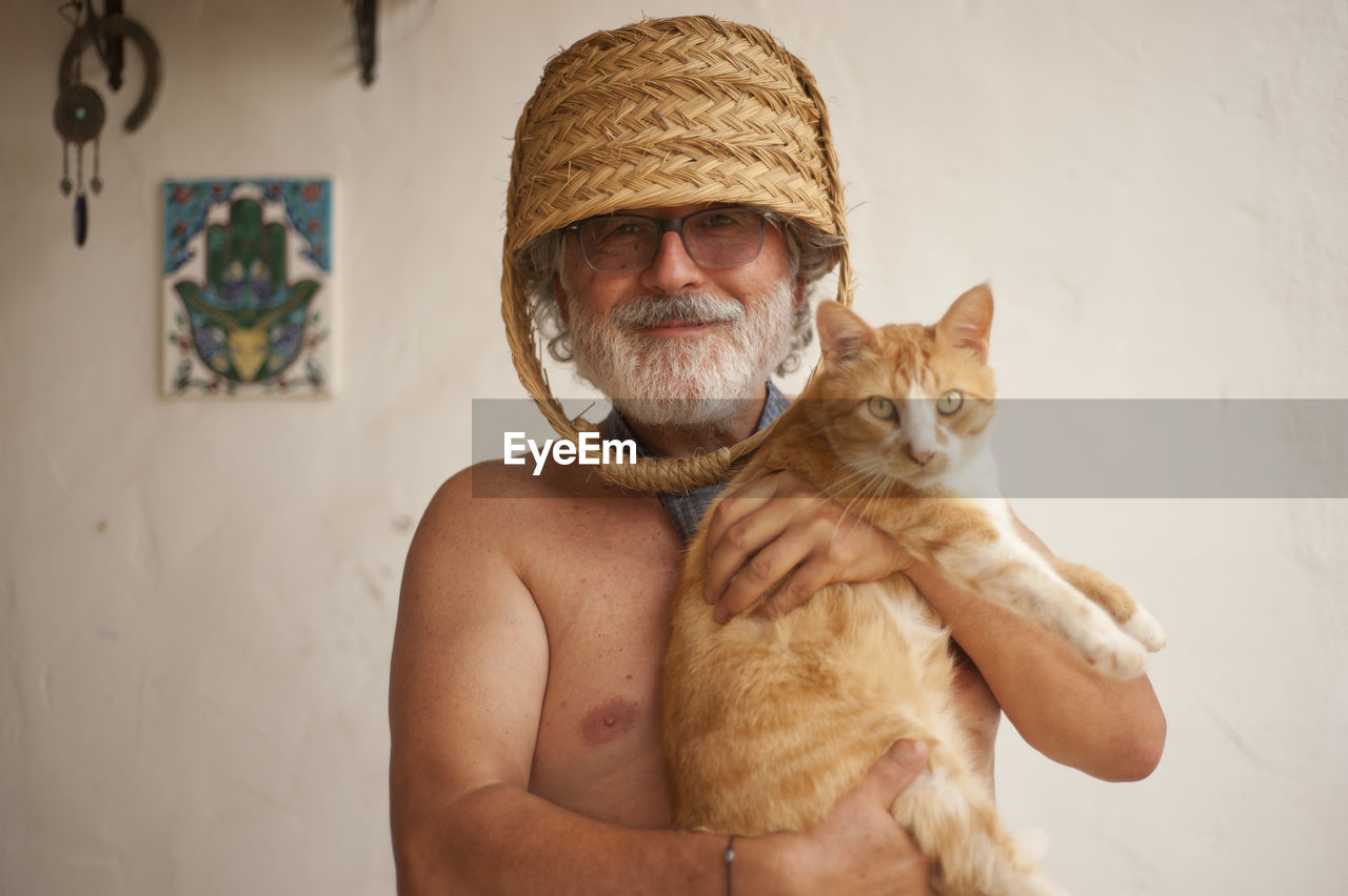 PORTRAIT OF A MAN WEARING CAT