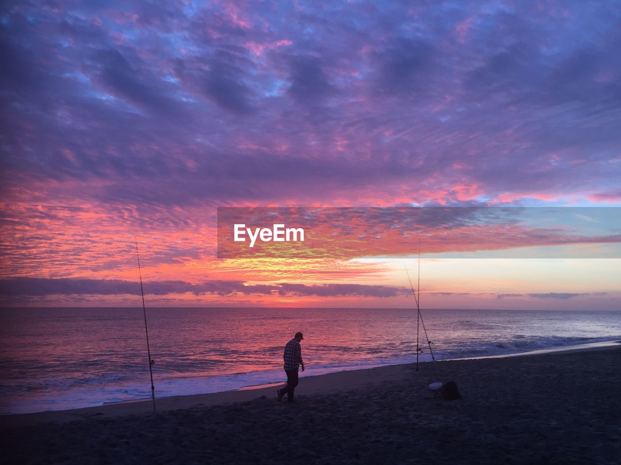 SILHOUETTE MAN FISHING AT BEACH DURING SUNSET