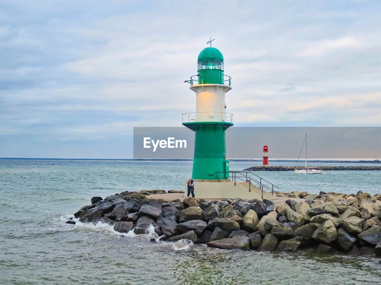 LIGHTHOUSE ON ROCK AT SEA AGAINST SKY