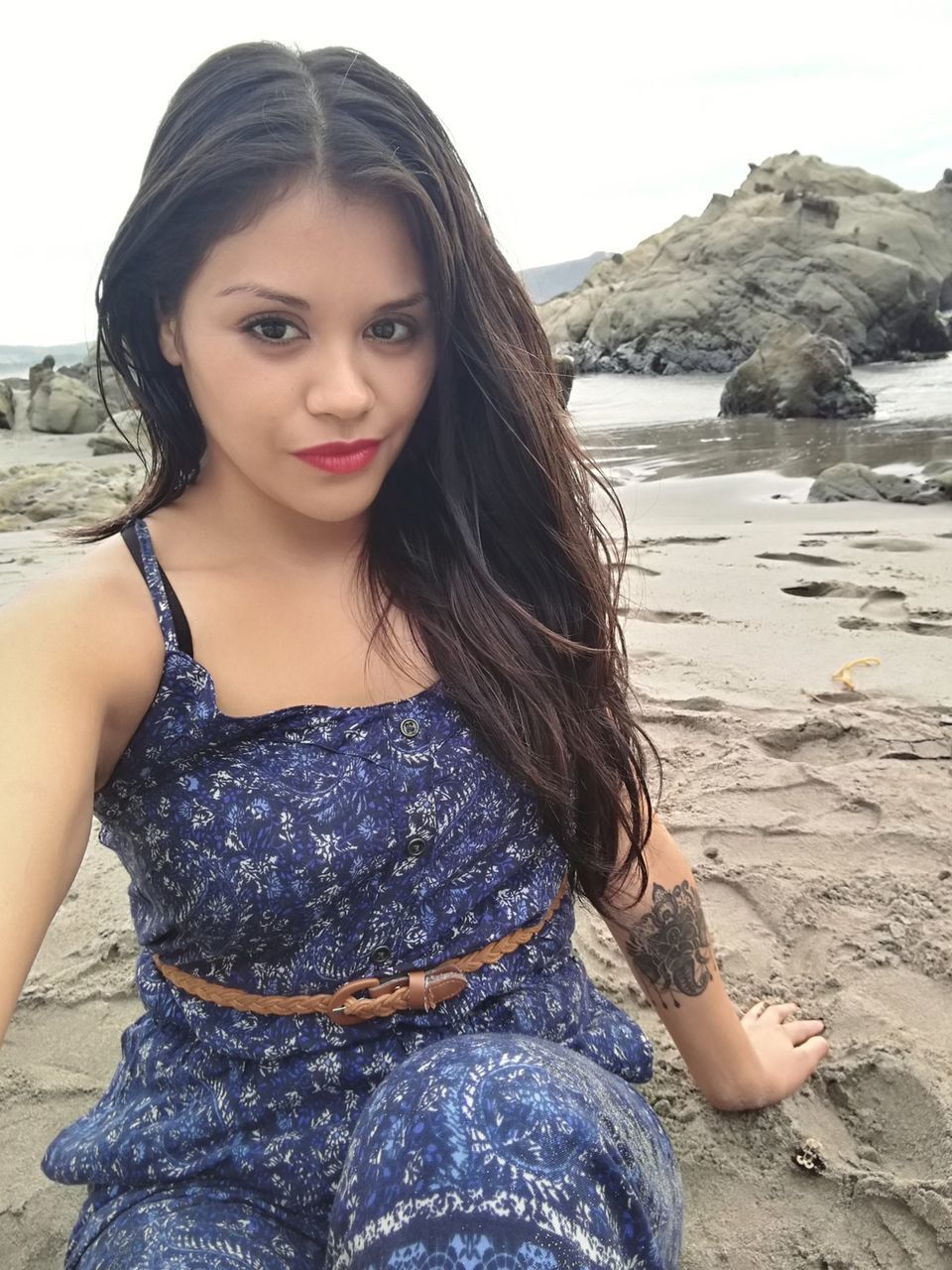 Portrait of young woman sitting at beach