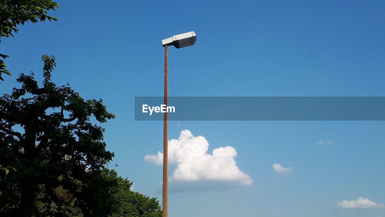 sky, street light, lighting, cloud, tree, light fixture, nature, low angle view, blue, lighting equipment, plant, street, no people, day, outdoors, wind, pole