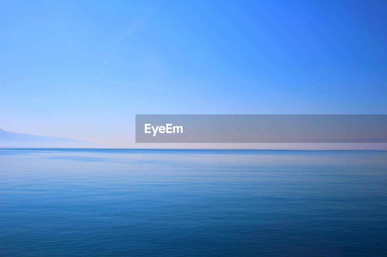 Scenic view of sea against clear blue sky